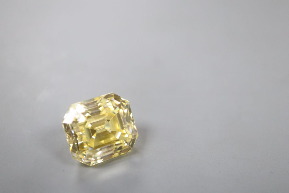 An unmounted emerald cut yellow gemstone, possibly cubic zirconia, weighing approximately 29.00ct.